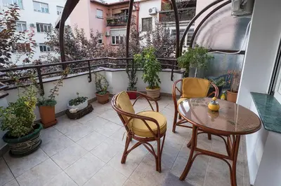 a balcony with a table and chairs and potted plants at Cozy studio with a terrace near Slavija square in Sajmište