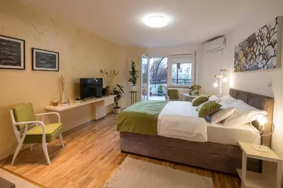 a bedroom with a bed and a desk and a tv at Cozy studio with a terrace near Slavija square in Sajmište