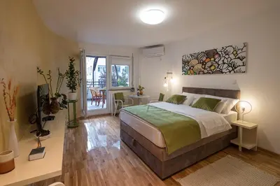 a bedroom with a bed and a table with chairs at Cozy studio with a terrace near Slavija square in Sajmište