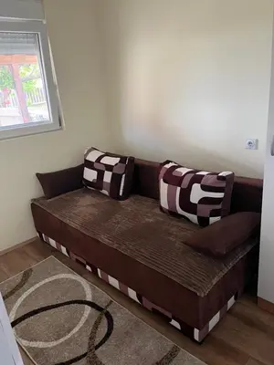 a brown couch in a living room with a window at Tea i Una in Arandjelovac