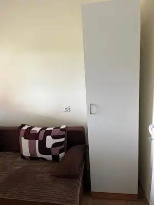 a living room with a couch with a striped pillow at Tea i Una in Arandjelovac