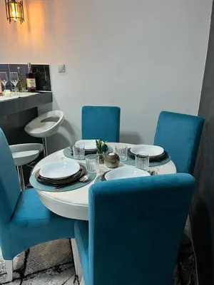 a table with blue chairs and a table with plates on it at Tea i Una in Arandjelovac