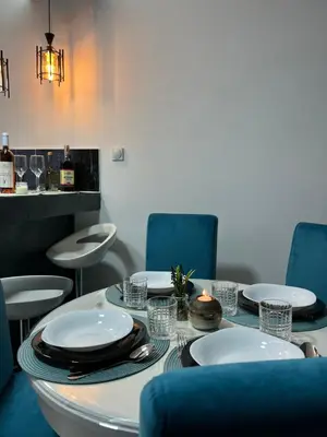a dining room with a table and blue chairs at Tea i Una in Arandjelovac