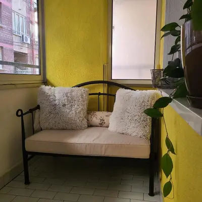 a bench with pillows on it in a room at Soulful Apartment Belgrade in Belgrade