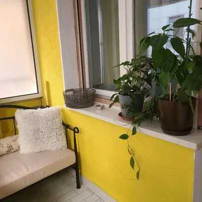 a yellow wall with a window with plants on it at Soulful Apartment Belgrade in Belgrade