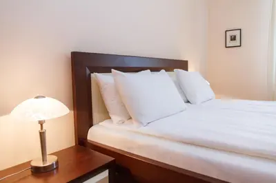 a bed with white pillows and a lamp on a table at Central Belgrade Apartments 1 in Belgrade