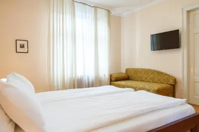 a bedroom with a bed and a couch and a television at Central Belgrade Apartments 1 in Belgrade