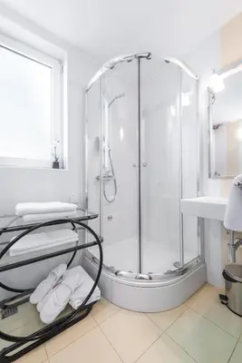 a bathroom with a shower with towels on a table at Central Belgrade Apartments 1 in Belgrade