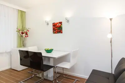a white dining room with a white table and chairs at Central Belgrade Apartments 3 in Belgrade