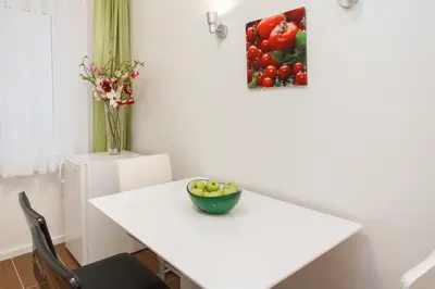 a white table with a bowl of fruit on it at Central Belgrade Apartments 3 in Belgrade