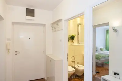 a bathroom with a sink and a toilet and a bed at Central Belgrade Apartments 3 in Belgrade