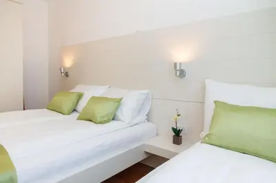 two beds with green and white pillows in a room at Central Belgrade Apartments 3 in Belgrade