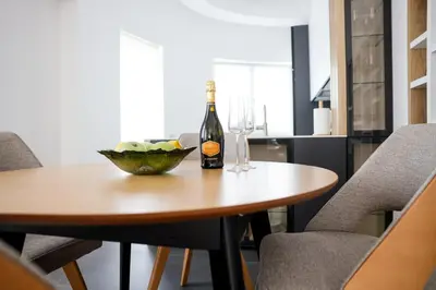 a table with a bottle of wine and a bowl of fruit at Villa Vanja Belgrade in Belgrade