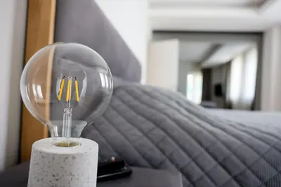 a lamp sitting on a table next to a bed at Villa Vanja Belgrade in Belgrade