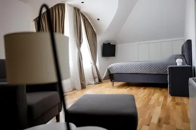 a bedroom with a bed and a chair in a room at Villa Vanja Belgrade in Belgrade