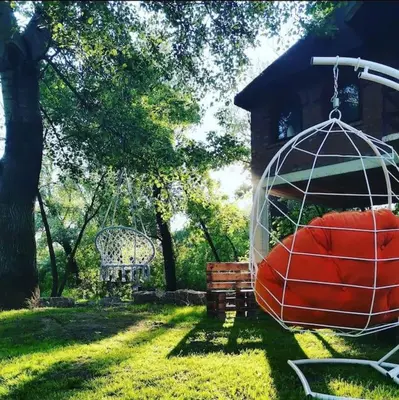 a swing in a cage in a yard with a bench at River House in Belgrade