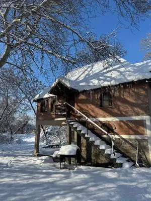 a log cabin with snow on the roof at River House in Belgrade