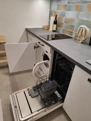 an open dishwasher in a kitchen with a counter at Dorćol Central Apartment-NEW in Belgrade