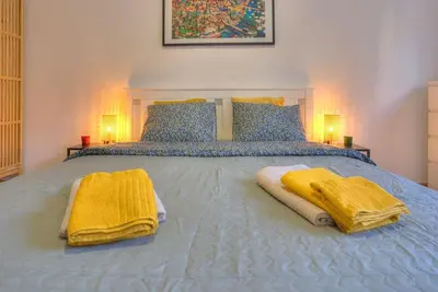 a bedroom with a bed with yellow towels on it at Dorćol Central Apartment-NEW in Belgrade