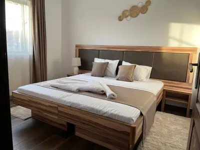 a bedroom with a large bed with two towels on it at Airport SKY apartments LUX in Belgrade