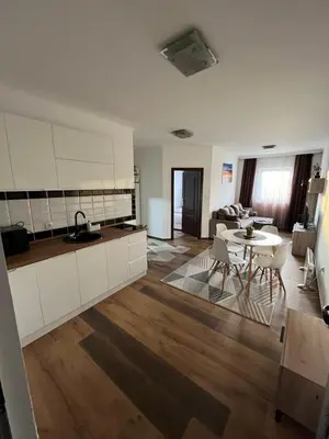 a kitchen and a living room with a table at Airport SKY apartments LUX in Belgrade