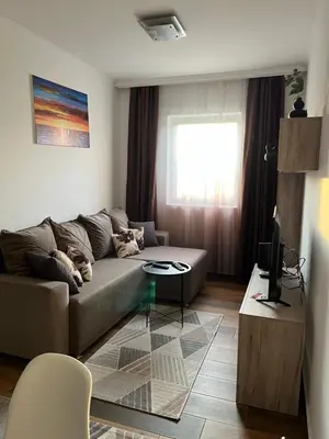 a living room with a couch and a table at Airport SKY apartments LUX in Belgrade