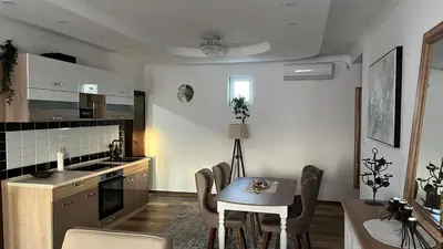 a kitchen with a table and chairs in a room at Airport SKY apartments LUX in Belgrade