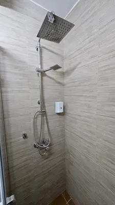 a shower with a shower head in a bathroom at Apartman Pavlovic 2 in Dušanovac (historical)