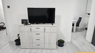 a television on a wooden dresser in a living room at Apartman Pavlovic 2 in Dušanovac (historical)