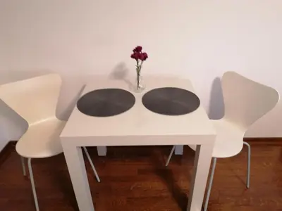 a white table with white chairs and a vase with flowers at Kalemegdan centar in Belgrade