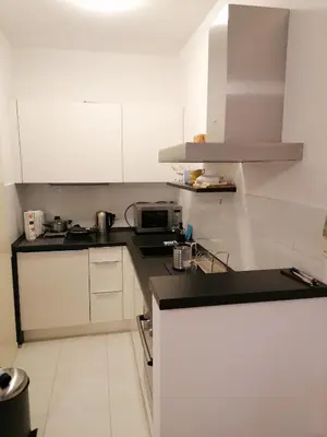 a kitchen with white cabinets and a black counter top at Kalemegdan centar in Belgrade