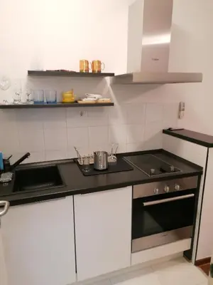 a kitchen with white cabinets and a black counter top at Kalemegdan centar in Belgrade