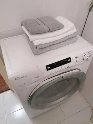 a white washing machine with towels on top of it at Kalemegdan centar in Belgrade