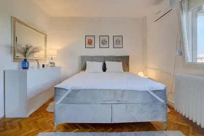 a bedroom with a bed and a large window at City View in Dušanovac (historical)