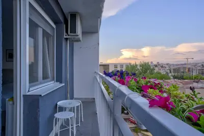 a balcony with flowers and a stool on a building at City View in Dušanovac (historical)