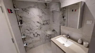 a white bathroom with a sink and a shower at BW Central View - Belgrade Waterfront in Belgrade