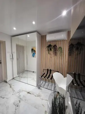 a lobby with a mirror and a white table and chairs at Luxury Central Square Apartment 2214 in Belgrade