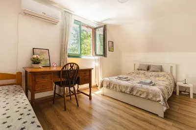 a bedroom with a bed and a desk and a chair at Vikendica WoodNook Kosmaj - Šumski kutak in Sopot