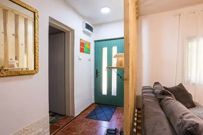 a living room with a couch and a mirror at Vikendica WoodNook Kosmaj - Šumski kutak in Sopot
