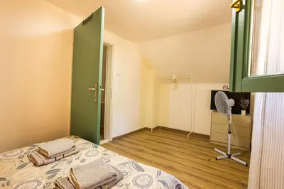 a bedroom with a bed and a green door at Vikendica WoodNook Kosmaj - Šumski kutak in Sopot