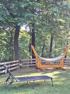 a hammock and a bench in a park at Vikendica WoodNook Kosmaj - Šumski kutak in Sopot