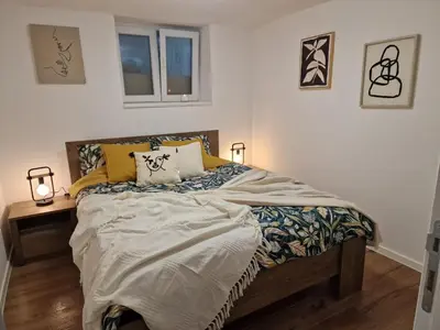 a bedroom with a bed with two lamps and two windows at Apartman Pobednik in Belgrade