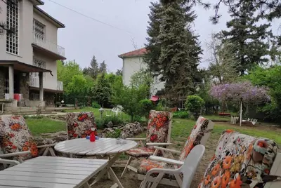 a patio with a table and chairs in a yard at Apartman Pobednik in Belgrade