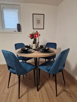 a dining room table and chairs with blue chairs at Apartman Pobednik in Belgrade
