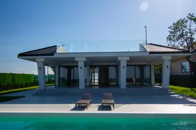 two chairs sitting in front of a pavilion next to a pool at Vila Julija in Surduk