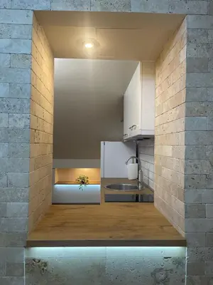 a kitchen with white appliances and a brick wall at Apartman Maki in Pančevo