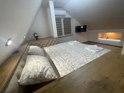 a bedroom with a large bed and a window at Apartman Maki in Pančevo