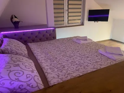a purple bed in a bedroom with purple lighting at Apartman Maki in Pančevo