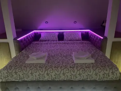 a purple bedroom with a bed with purple lighting at Apartman Maki in Pančevo