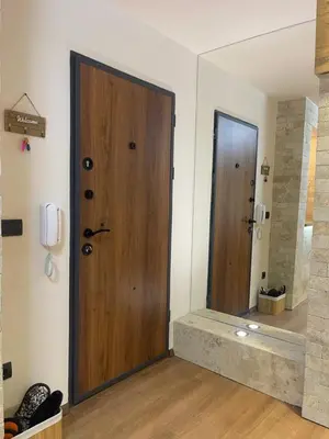 a wooden door in a room with a mirror at Apartman Maki in Pančevo
